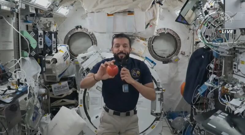 Sultan Al Neyadi shows off an apple during a live call with Ras Al Khaimah pupils on June 14, 2023. Photo: Nasa TV