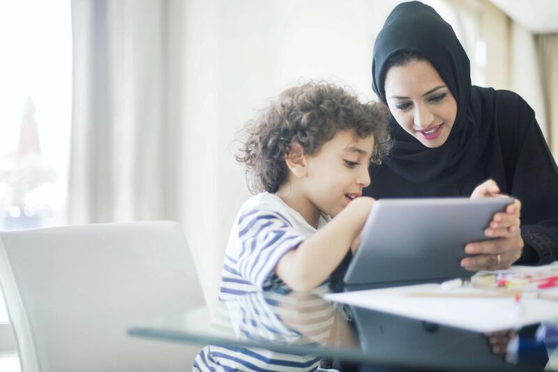 Middle eastern mother helping her child with homework.