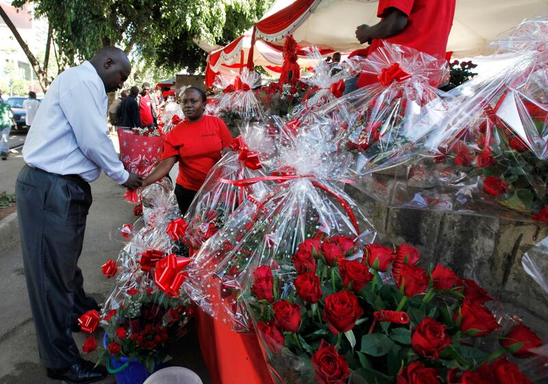 A Kenyan woman sells a bouquet of red roses to a customer for celebrations of Valentine's Day at a flower market in Nairobi, Kenya, Tuesday, Feb. 14, 2012. (AP Photo/Sayyid Azim) *** Local Caption ***  Kenya Valentines Day.JPEG-0e97f.jpg