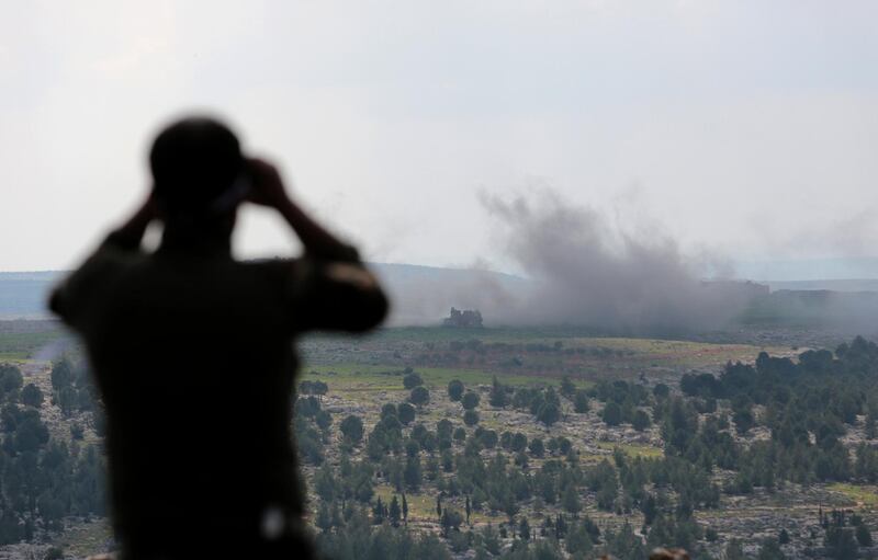 epa06600953 A Turkey-backed Free Syrian Army soldier watches with binoculars as smoke rises after a bomb attack during an offensive, at Der Mismis Village, southeast of Afrin, Syria, 13 March 2018. According to media reports, the Turkish army and its allied Syrian militias on 10 March continued to encircle the city of Afrin in the Kurdish-held enclave of the same name in northwest Syrian, taking control of nine towns. The Turkish army on 20 January launched 'Operation Olive Branch' in Syria's northern regions against the Kurdish Popular Protection Units (YPG) forces and the Syrian Democratic Forces (SDF) which control the city of Afrin. Turkey classifies the YPG as a terrorist organization. The Turkish-backed Free Syrian Army is an armed rebel military group that operates in northern Syria and is supported by the Turkish army.  EPA/STR