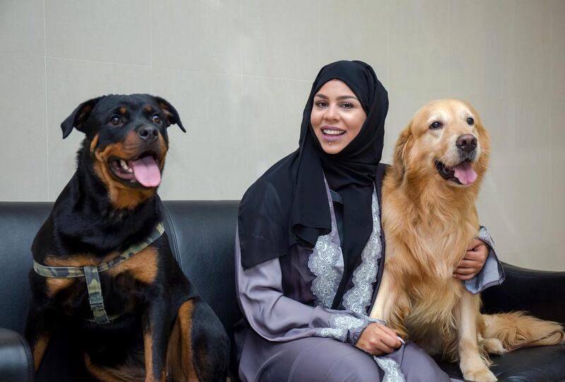 Sara Al Zaki helps rescue and rehome banned breeds of animals that have been used in dog fighting. She is seen with Dusty the Rottweiler, left, and Jess the Golden Retriever. Victor Besa for The National