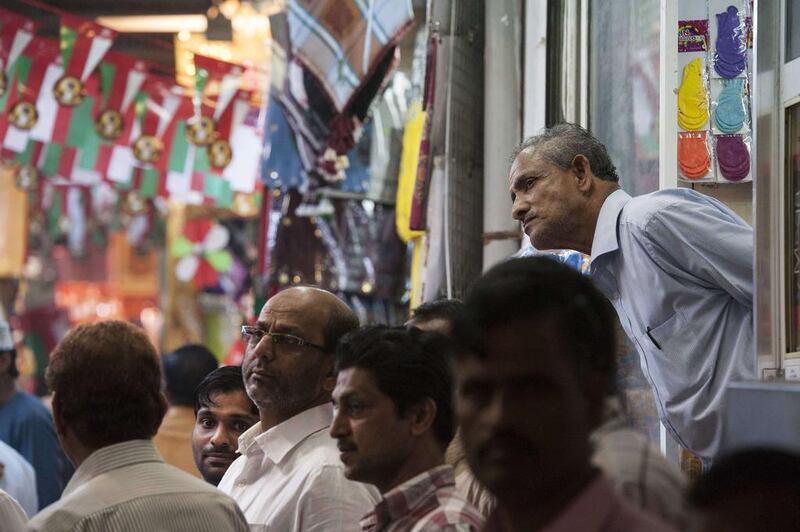 People watch as Mr Kerry shops at the Mattrah souk. Nicholas Kamm / AP