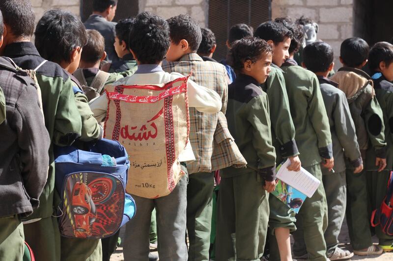 A child at a school in Sanaa carries a rice sack to function as a back-pack.Ali Alsonidar