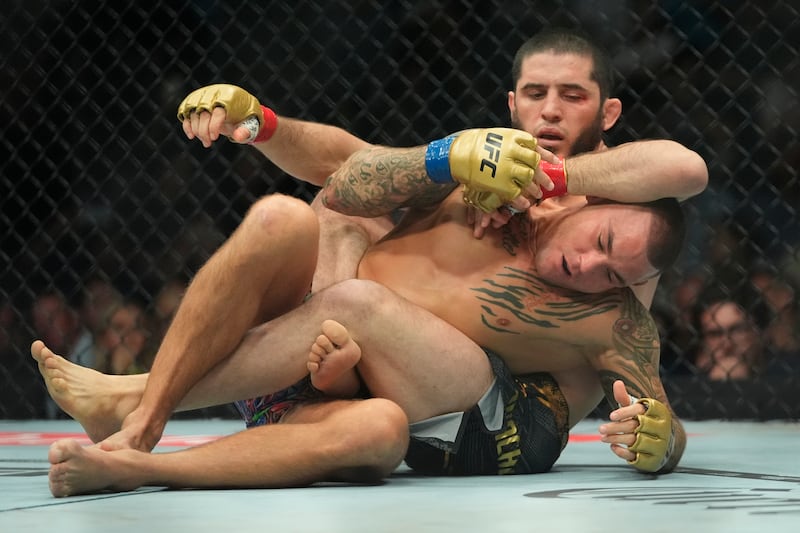Islam Makhachev attempts to submit Dustin Poirier during the first round of their fight at UFC 302. AP