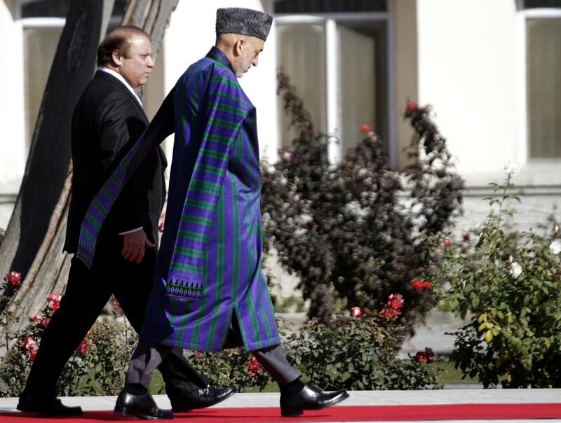 Former Afghan President Hamid Karzai walks with Pakistan's Prime Minister Nawaz Sharif  during their 2013 meeting in Kabul S Sabawoon / EPA