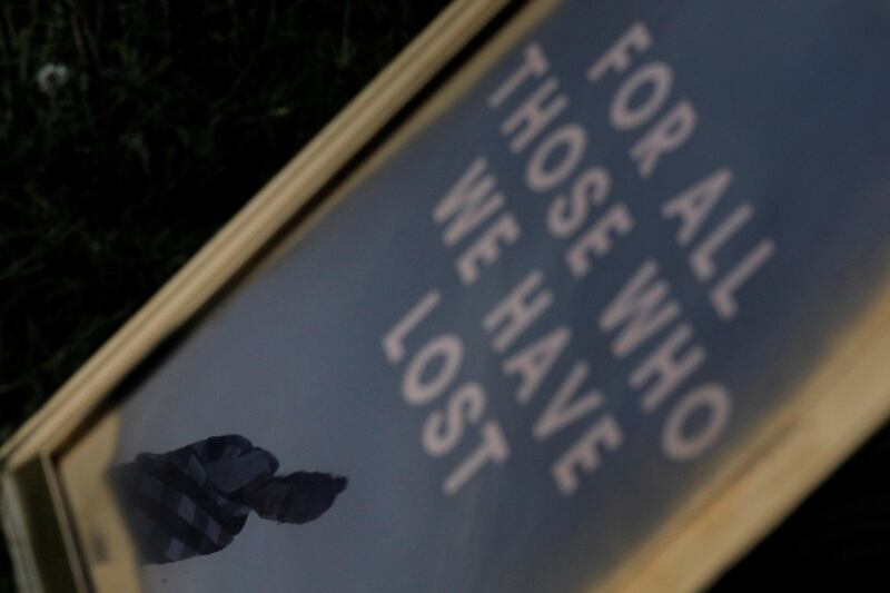 A man is reflected in a sign during a vigil held to remember George Floyd in Lynn, Massachusetts. Reuters