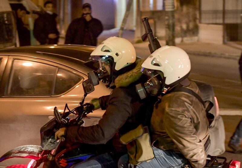 Tunisian security forces members wearing civilian clothing ride a motorcycle while one carries anti-riot arms ahead of clashes with protesters in the Ettadhamen city suburb on the northwestwern outskirts of Tunisia's capital Tunis amidst a wave of nightly protests in the North African country.   AFP