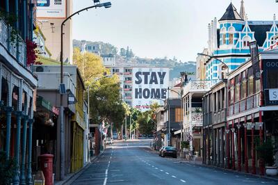 A general view of Long Street, usually one of the busiest and most popular entertainment areas with bars, clubs and restaurants in the city, with a billboard reading Stay Home, in Cape Town on April 3, 2020. South Africa came under a nationwide lockdown on March 27, 2020, joining other African countries imposing strict curfews and shutdowns in an attempt to halt the spread of the COVID-19 coronavirus across the continent. / AFP / RODGER BOSCH
