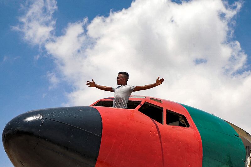 A youth stands in the cockpit of the aircraft being converted into a restaurant by Palestinian twins Atallah and Khamis All Sairafi