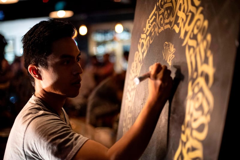 This photo taken on June 22, 2019 shows artist Taipan Lucero doing calligraphy using the indigenous script known as Baybayin, used before Spanish colonisation in 1521, at an event in Manila. Photos: AFP / Noel Celis
