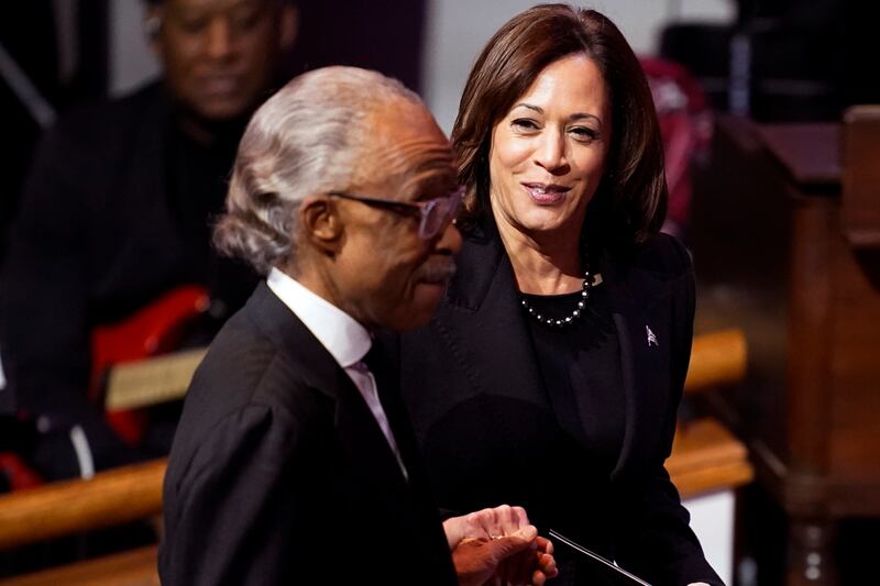 Mr Harris joins Rev Sharpton during the funeral service. AP