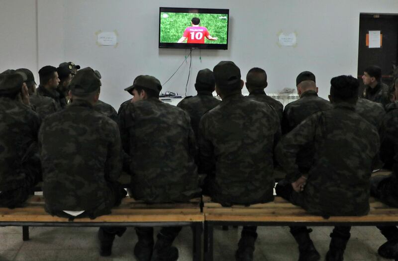 Palestinian security forces watch the World Cup 2022 Asian qualifying match between Palestine and Saudi Arabia in the northern Israeli occupied West Bank city of Nablus. The game, taking place in the Palestinian West Bank town of al-Ram, would mark a change in policy for Saudi Arabia, which has previously played matches against Palestine in third countries. Arab clubs and national teams have historically refused to play in the West Bank, where the Palestinian national team plays, as it required them to apply for Israeli entry permits.  AFP