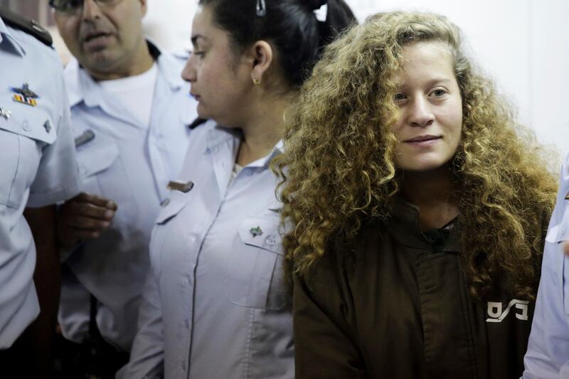 FILE - In this Dec. 28, 2017 file photo, Ahed Tamimi is brought to a courtroom inside Ofer military prison near Jerusalem. A senior Israeli official on Wednesday said he led a secret investigation into 16-year-old Palestinian protest icon Ahed Tamimi and her family, in part because their appearance, including "blond-haired, freckled" children in â€œWestern clothes,â€ made them seem less like â€œrealâ€ Palestinians. (AP Photo/Mahmoud Illean, File)