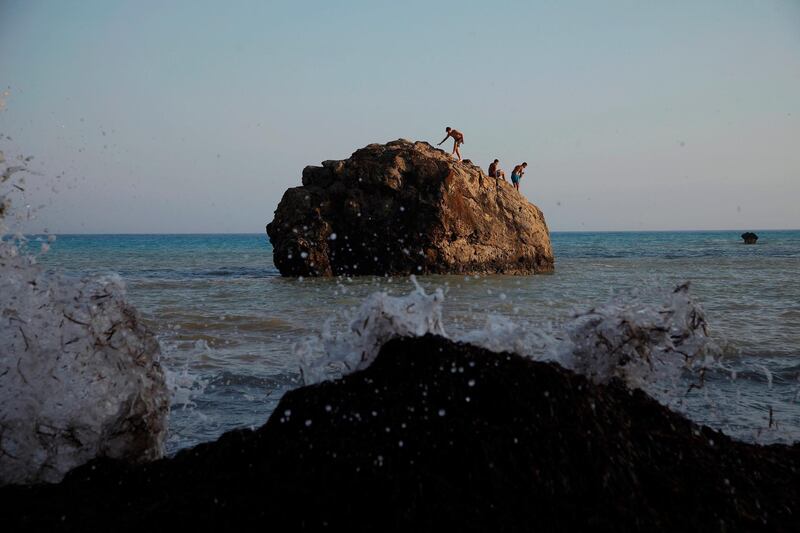 Swimmers are seen on a rock at the sea at Aphrodite's Rock, 'Petra tou Romiou', the spot where according to ancient Greek mythology the ancient goddess Aphrodite was born, near Paphos, Cyprus.  AP