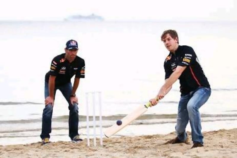 Sebastian Vettel tries his hand at beach cricket on St Kilda Beach, with teammate Mark Webber playing wicketkeeper in a bit of fun on Wednesday before their real jobs begin on Friday for the Grand Prix of Australia.