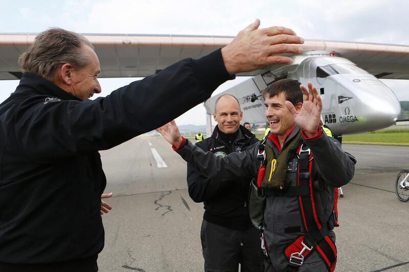 Solar Impulse co-founders Andre Borschberg, left, and Bertrand Piccard, centre, congratulate test pilot Markus Scherdel after the maiden flight of Solar Impulse 2. Denis Balibouse / Reuters