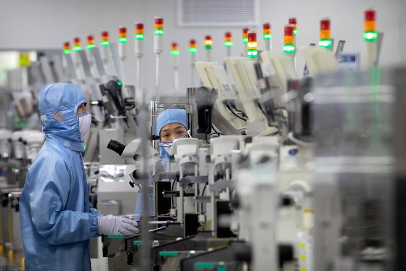 Employees work at a semiconductor production facility for Renesas Electronics during a government-organised tour for journalists in Beijing. AP