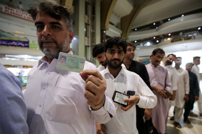 Shopkeepers wait to receive their Covid-19 vaccines at a shopping mall in Peshawar. EPA