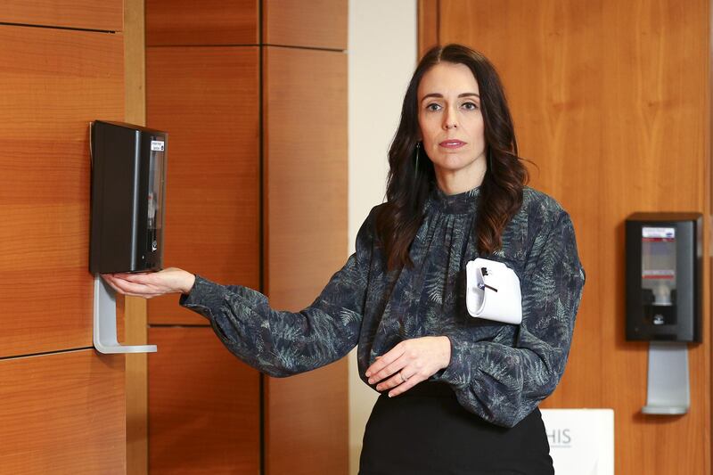 New Zealand Prime Minister Jacinda Ardern uses hand sanitiser as she leaves a press conference at Parliament in Wellington, New Zealand. Getty Images