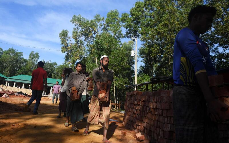 Bangladeshi labourers carry bricks in the construction site of the "Transit Camp". AFP