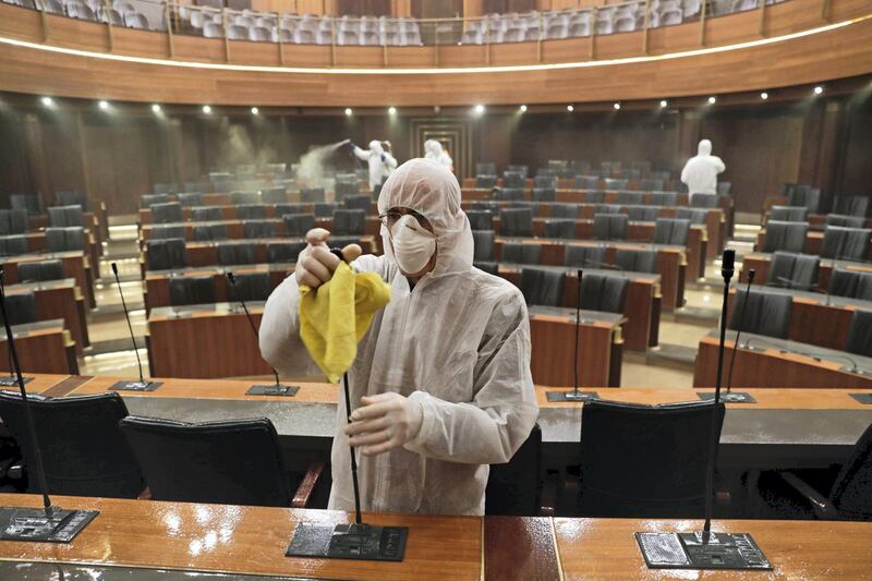 TOPSHOT - Sanitary workers disinfect the desks and chairs of the Lebanese Parliament in central Beirut on March 10, 2020 amid the spread of coronavirus in the country.  / AFP / ANWAR AMRO
