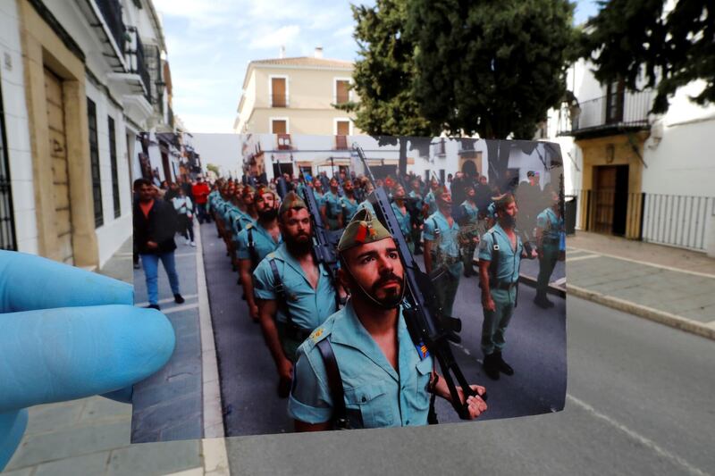 A Reuters photographer holds a picture of Spanish legionnaires marching before a procession taken in April, 2019, in front of the street of the procession, on Palm Sunday, the first day of Holy Week, amid the coronavirus disease outbreak, in Ronda, southern Spain. Reuters