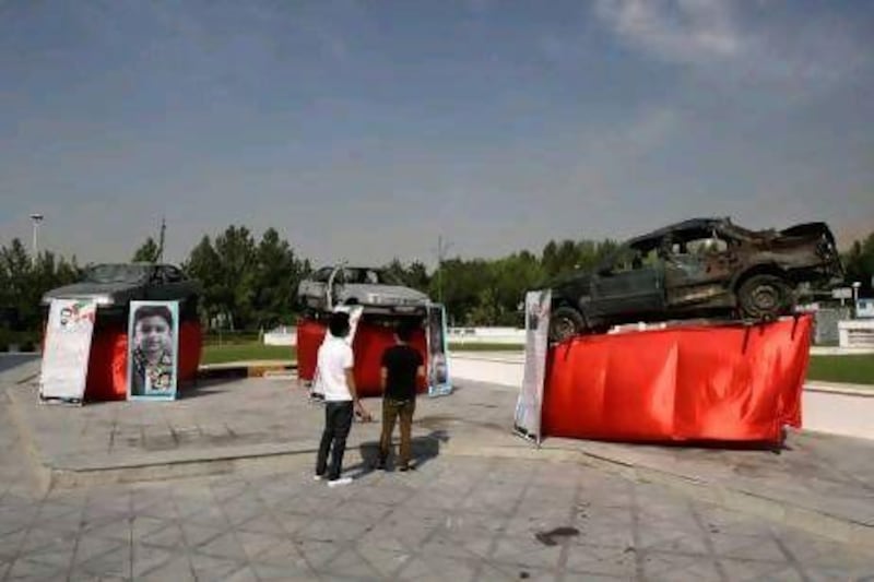 Damaged cars that three Iranian scientists, Masoud Ali Mohammadi, right, Majid Shahriari, centre, and Mostafa Ahmadi Roshan were riding in when they were killed in bombings over the past three years are displayed outside a conference hall hosting the meeting of the Non-Aligned Movement in Tehran.