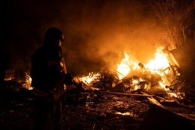 A firefighter works at a site of vehicle parking area damaged by remains of Russian Kinzhal attack on Kyiv. Reuters