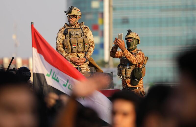 Iraqi security forces monitor a protest outside the Basra Governorate's building in the southern city of Basra. AFP
