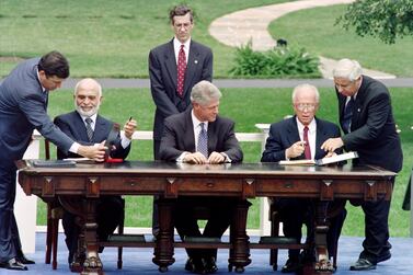 Israeli Prime Minister Yitzhak Rabin (2nd R) and Jordan's King Hussein (2nd L) are directed where to sign by unidentified aides as US President Bill Clinton (C) looks on during ceremonies at the White House in Washington, on July 25, 1994. - Prime Minister Rabin and King Hussein signed a declaration of peace designed to end 46 years of hostility between their countries. (Photo by Paul J. RICHARDS / AFP)