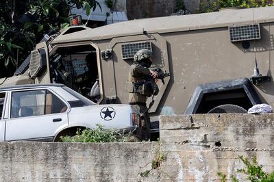 An Israeli soldier brandishes a weapon during a raid in the West Bank city of Tubas on Saturday. Reuters 