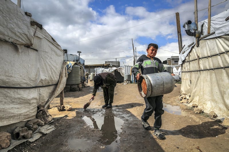 20 February 2021, Lebanon, Marj: A Syrian refugee flushes rain water outside her tent following heavy rain, at Marj Syrian refugee camp in Lebanon's Bekaa valley. Syrian refugees have been affected by heavy rain and snow, high winds, and frigid temperatures that have hit Lebanon. Photo: Marwan Naamani/dpa (Photo by Marwan Naamani/picture alliance via Getty Images)