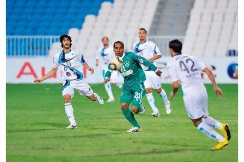Adel Abdullah, centre, of Al Shabab chases down the ball against Baniyas last night.