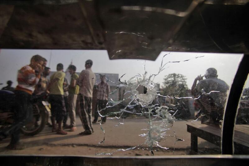 Indian villagers gather around an abandoned car with a broken window with shell holes allegedly caused from firing from Pakistan side at Garkhal village. Channi Anand / AP Photo