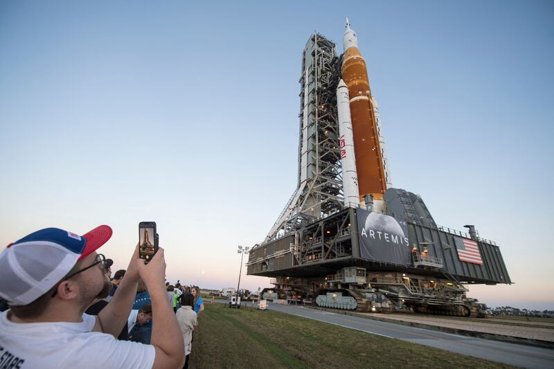 Invited guests and Nasa employees take photos as Nasa's Space Launch System rocket is rolled out of the Vehicle Assembly Building for the first time. AFP