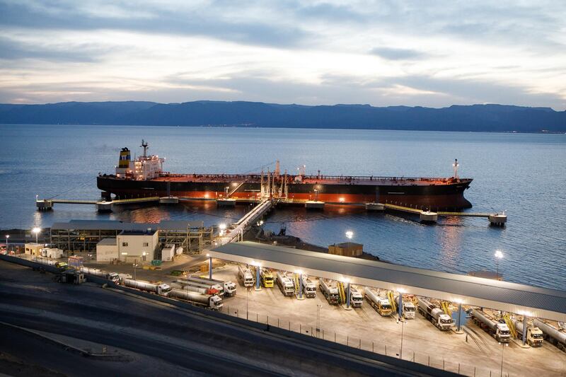Tanker trucks fill up with crude oil for delivery to the Jordan Petroleum Refinery Co. on the quayside near a crude oil tanker, operated by Navigator Gas LLC, at Aqaba port, operated by Aqaba Development Corp., in Aqaba, Jordan, on Wednesday, April 11, 2018. Both the LNG and the liquefied petroleum gas (LPG) terminals were developed to secure the supply of gas resources after the disruption in Egyptian natural gas imports in 2010. Photographer: Annie Sakkab/Bloomberg