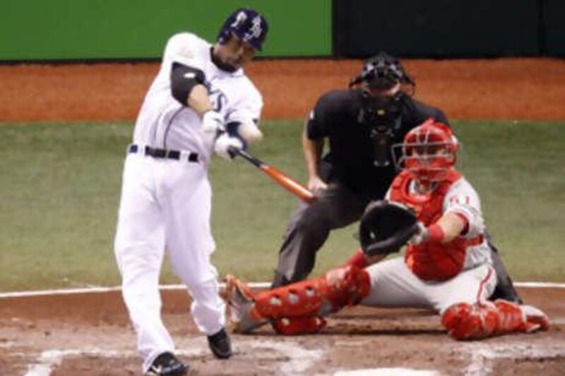 The Tampa Bay Rays batter Carl Crawford, left, hits a solo home run in the fourth inning off the Philadelphia Phillies starting pitcher Cole Hamels in Game 1.