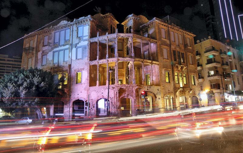 This Thursday, Oct. 26, 2017 photo, made with a long exposure, shows cars passing in front of Beit Beirut, the nearly 100 year-old house that served as a sniper position during Lebanon's civil war and now is hosting an exhibition by Zena El Khalil, in Beirut, Lebanon. El Khalil has tapped into wounds more than forty years old in war-scarred Lebanon. (AP Photo/Bilal Hussein)