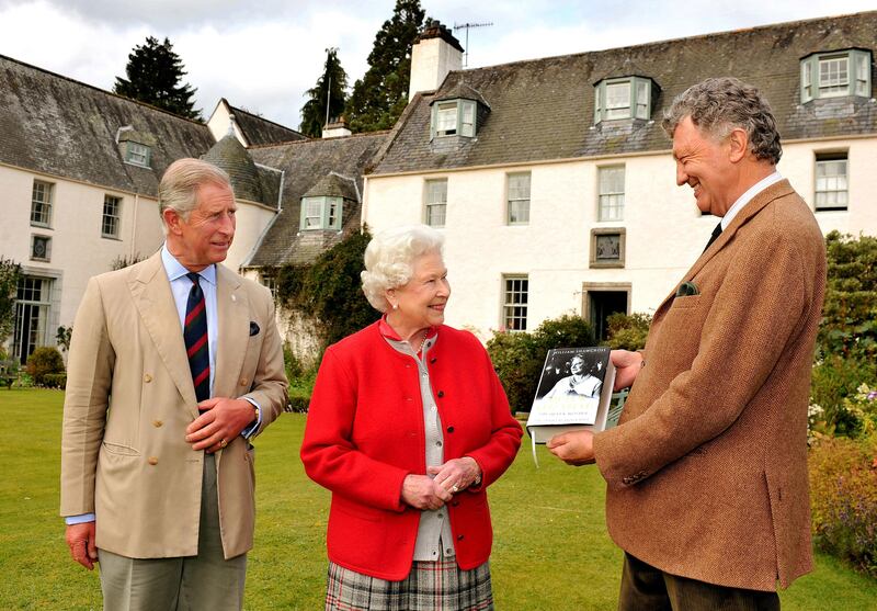 Queen Elizabeth, alongside Prince Charles, is presented with one of the first copies of 'Queen Elizabeth the Queen Mother, The Official Biography' by author William Shawcross in the garden at Birkhall, the Scottish home of the prince, in 2009.