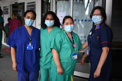 Members of staff at the Chelsea and Westminster Hospital pose for a photograph after participating in a national NHS (National Health Service) celebration clap outside the hospital in London on July 5, 2020, to mark its 72nd anniversary. - This year's celebration is particularly poignant given the challenging conditions NHS staff have had to work under over the past four months amid the coronavirus outbreak. (Photo by DANIEL LEAL-OLIVAS / AFP)