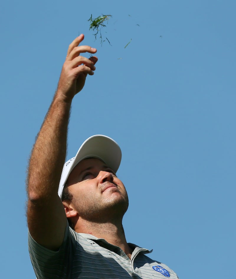 Richard Sterne of South Africa checks the wind direction before teeing off on the fouth and last round of the Omega Dubai Desert Classic in Dubai, on February 03, 2013.       AFP PHOTO/MARWAN NAAMANI
 *** Local Caption ***  403254-01-08.jpg