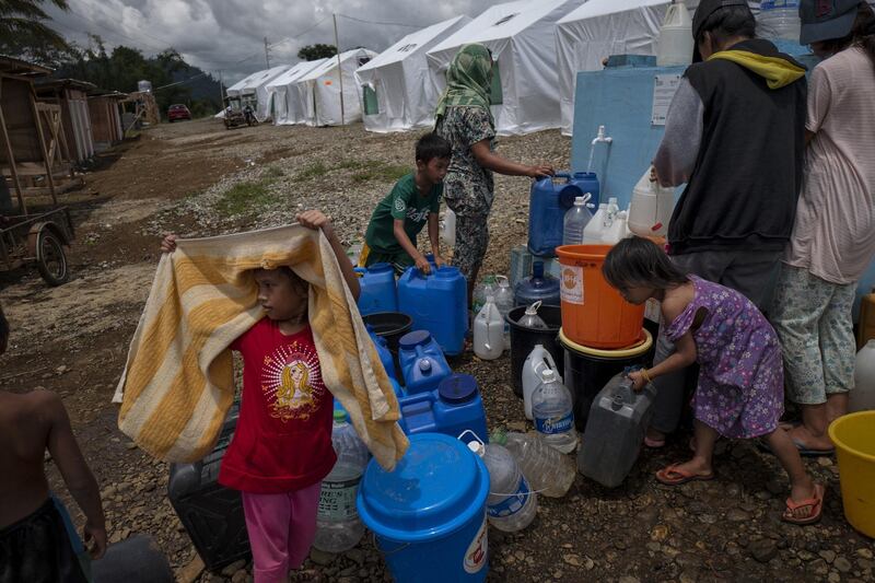 Displaced Marawi residents queue for water.