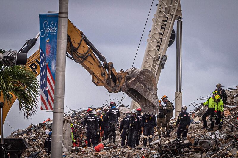 Search and rescue teams look for possible survivors in the rubble of the partially collapsed 12-story Champlain Towers South building can be seen on June 28, 2021 in Surfside, Florida. Questions mounted Monday about how a residential building in the Miami area could have collapsed so quickly and violently last week, as the death toll rose to 11 with 150 still unaccounted for, and desperate families feared the worst. / AFP / Giorgio Viera
