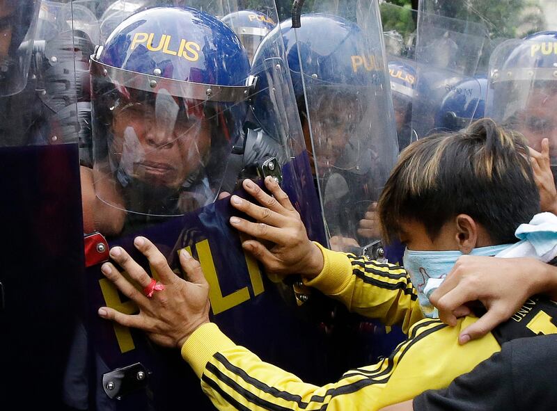 A riot police reacts as a protester pushes his shield during a rally near the US Embassy in Manila to protest this weekend's visit of US president Donald Trump. Trump is currently on a visit to Asia with the Philippines as his last stop for the ASEAN leaders' summit and related summits between the regional grouping and its Dialogue Partners. Aaron Favila / AP Photo