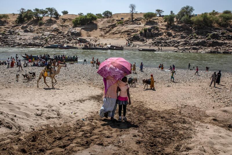 Refugees who fled the conflict in Ethiopia's Tigray region arrive on the banks of the Tekeze River on the Sudan-Ethiopia border. AP