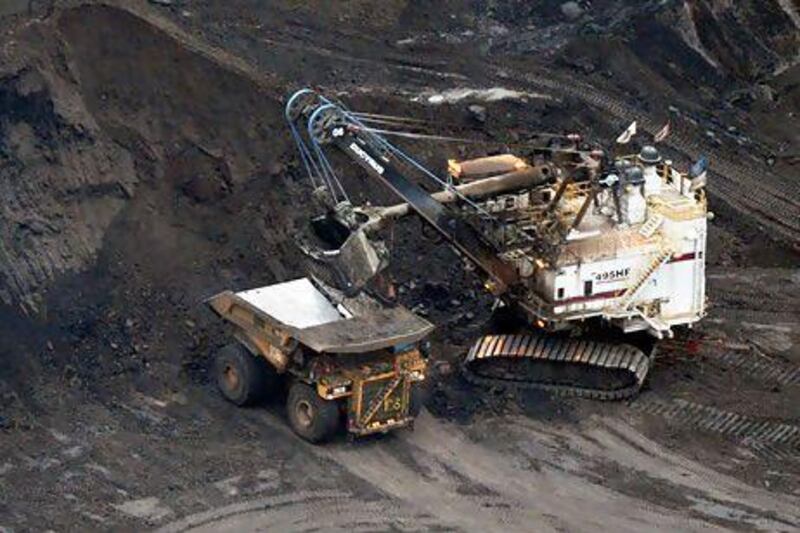 A large excavator loads a truck with oil sands at the Shell Albian mine near the town of Fort McMurray in Alberta Province, Canada on October 23, 2009. Greenpeace is calling for an end to oil sands mining in the region due to their greenhouse gas emissions and have recently staged sit-ins which briefly halted production at several mines. At an estimated 175 billion barrels, Alberta's oil sands are the second largest oil reserve in the world behind Saudi Arabia, but they were neglected for years, except by local companies, because of high extraction costs. Since 2000, skyrocketing crude oil prices and improved extraction methods have made exploitation more economical, and have lured several multinational oil companies to mine the sands. AFP PHOTO/Mark RALSTON *** Local Caption *** 229142-01-08.jpg