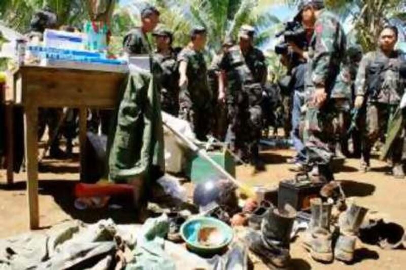 Philippine Army officials led by Major General Nemehias Pajarito, 1st Tabak division commander (4L) inspect recovered medical and personal belongings after capturing Camp Bilal in Poona Piagapo in The Lanao del Norte Province of the southern Philippines on August 28, 2008, the former base of Muslim rebel of Commander Abdurahman Macapaar, also known as Commander Bravo, one of the renegade Moro Islamic Liberation Front (MILF) rebels.      Philippine troops overran the rebel Muslim stronghold after weeks of fighting that has left about 150 dead, a military spokesman said. The 100-hectare- (250-acre) training camp borders two remote villages from where Bravo's men had planned deadly August 18 raids against civilian communities. Commander Bravo's headquarters is seen at the centre. AFP PHOTO/STR *** Local Caption ***  186786-01-08.jpg