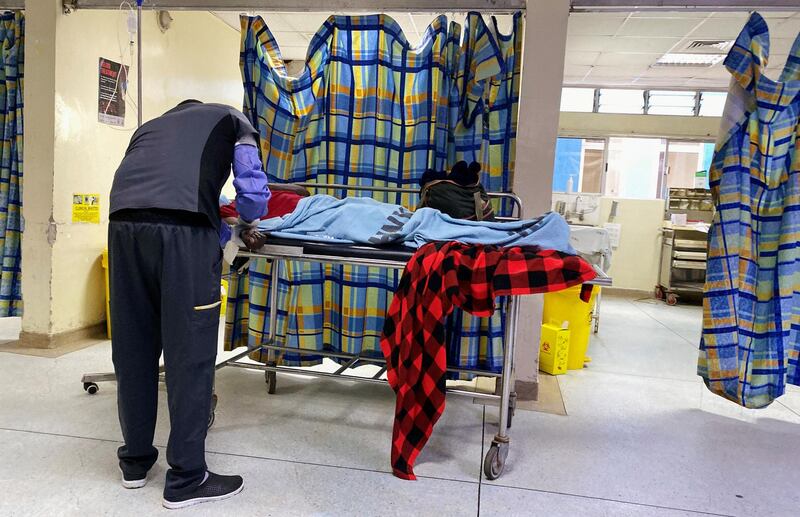 An unidentified hospital worker attends to a patient outside the consultation cubicle at the emergency section of the Kenyatta National Hospital during a doctors' strike, amid the spread of the coronavirus, in Nairobi, Kenya December 21, 2020. Reuters
