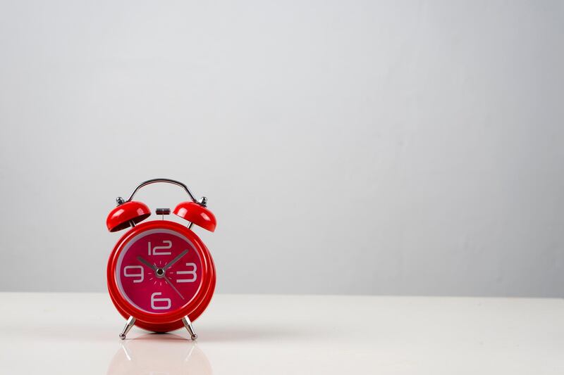 Photo for clock with negative space  on the table in white background. Getty Images