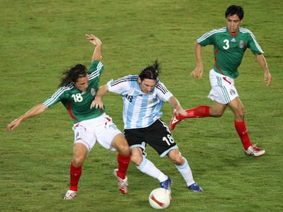 Argentina's Lionel Messi (C) manages to steal the ball between Mexico's players Andres Guardado (L) and Fausto Pinto during their Copa America Venezuela-2007 semifinal match in Puerto Ordaz, Venezuela.  AFP PHOTO/VANDERLEI ALMEIDA (Photo by VANDERLEI ALMEIDA / AFP)